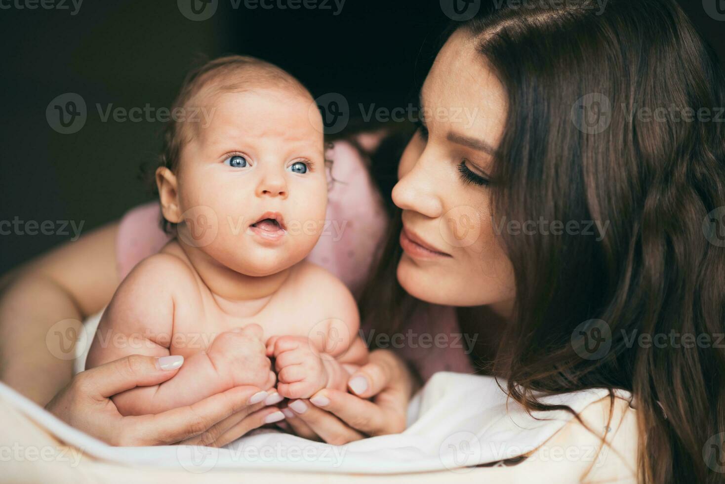 portret van een jong vrouw wie teder geeft voor haar baby foto