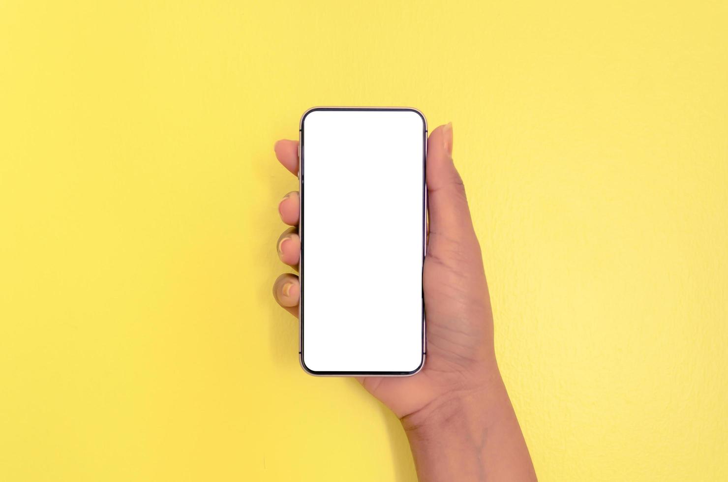 een hand met smartphone met witte schermachtergrond. foto