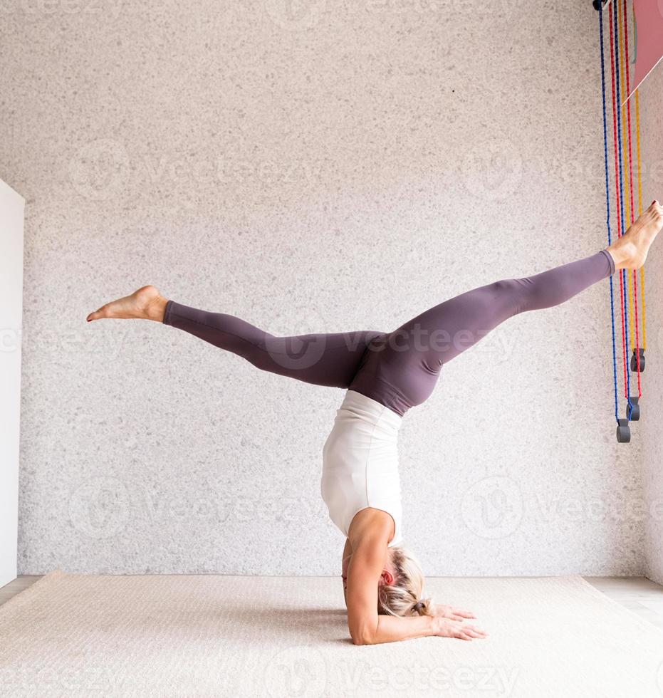 jonge aantrekkelijke vrouw die yoga beoefent, sportkleding draagt foto