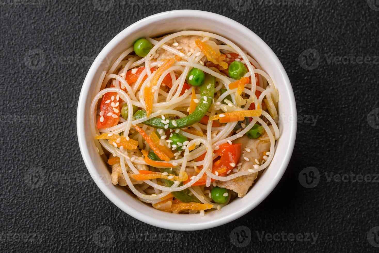 smakelijk schotel van Aziatisch keuken met rijst- noedels, kip, asperges, peper, sesam zaden foto