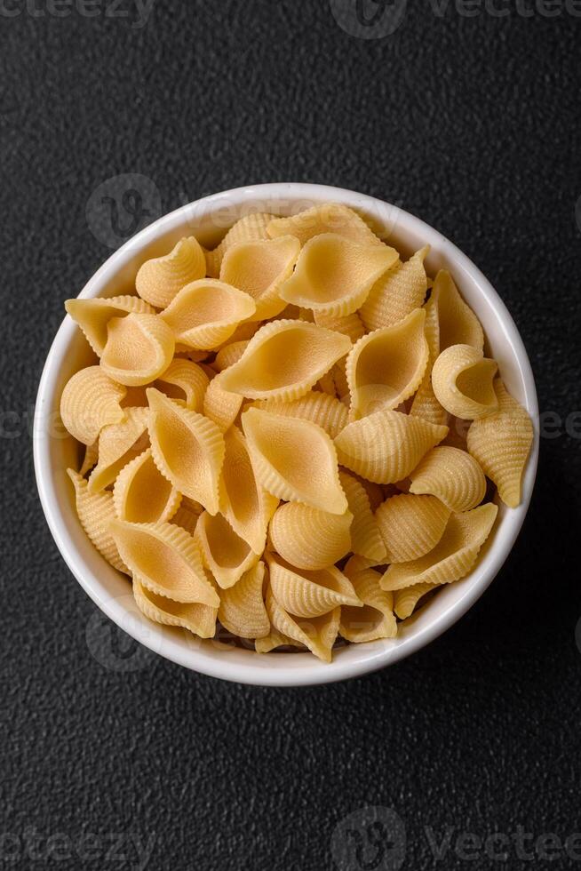 rauw Italiaans pasta conchiglie van durum tarwe met groenten, zout en specerijen foto