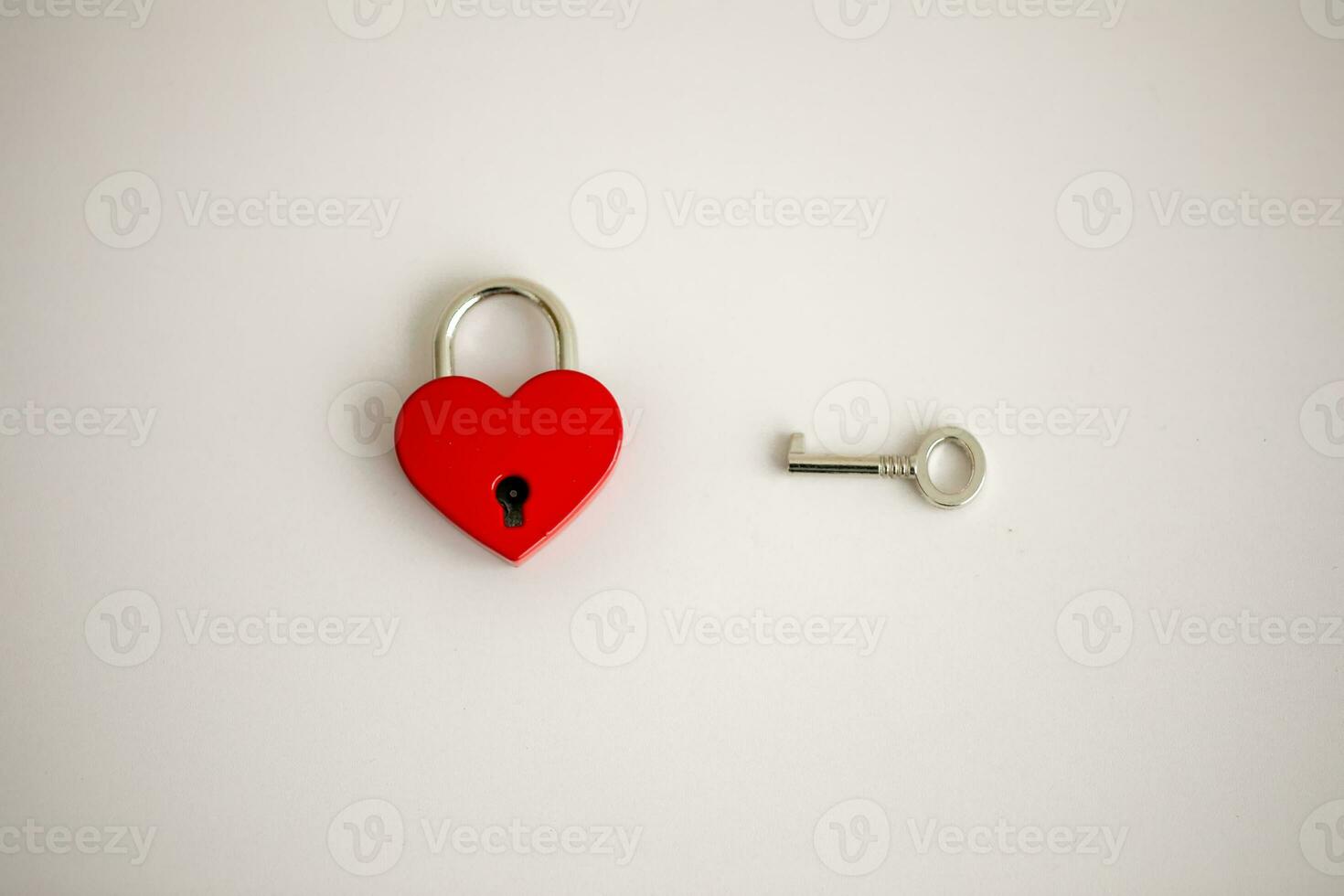 een rood hart vormig hangslot met een sleutel tegen een wit achtergrond, liefde concept. foto