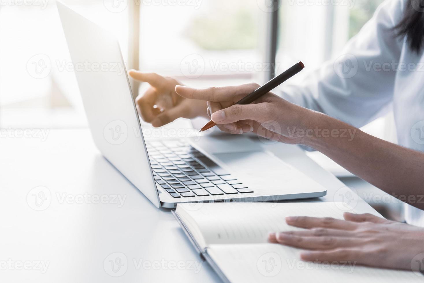 close-up van twee zakenvrouwen die laptop gebruiken en schrijven foto