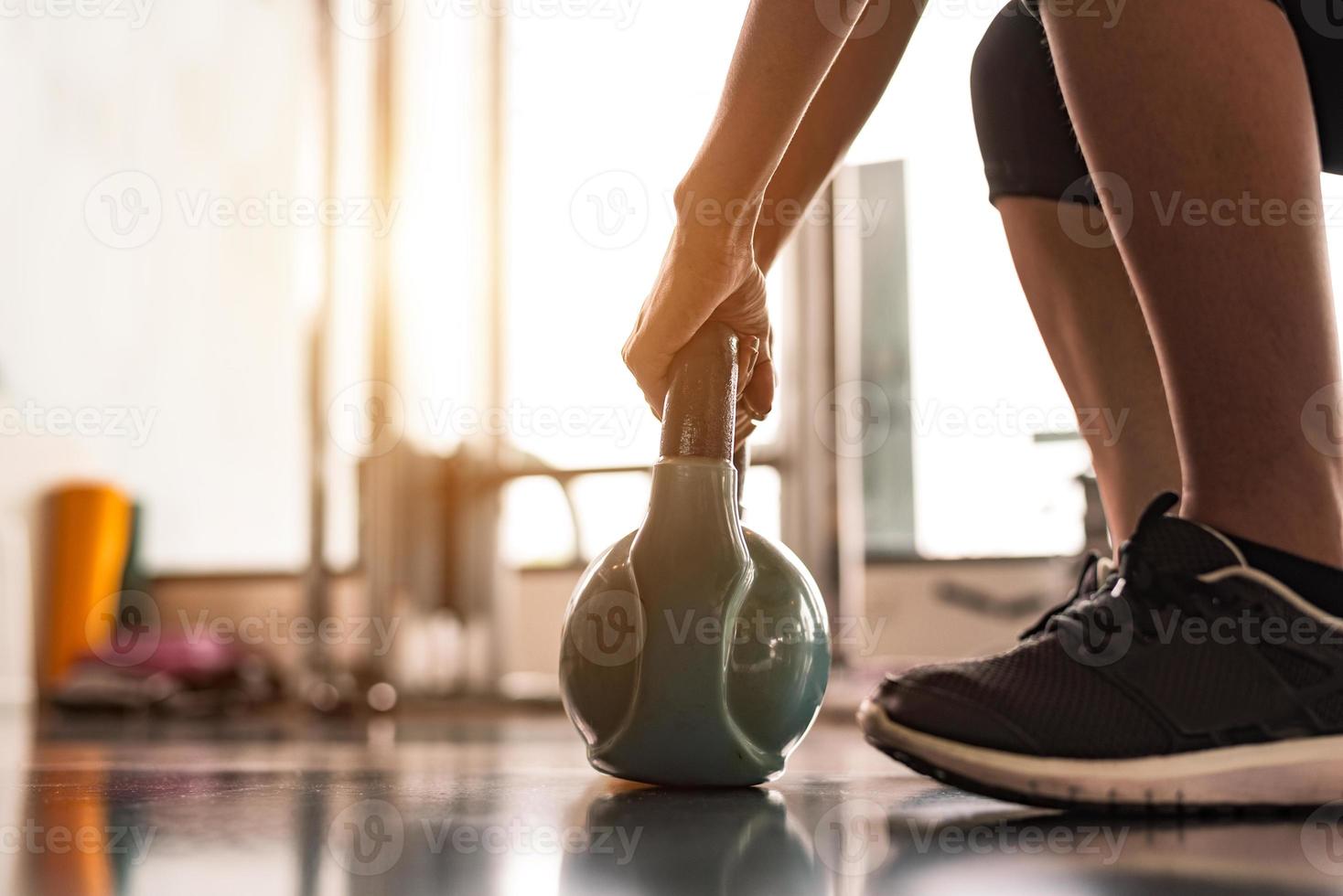 close up van vrouw tillen kettlebell foto