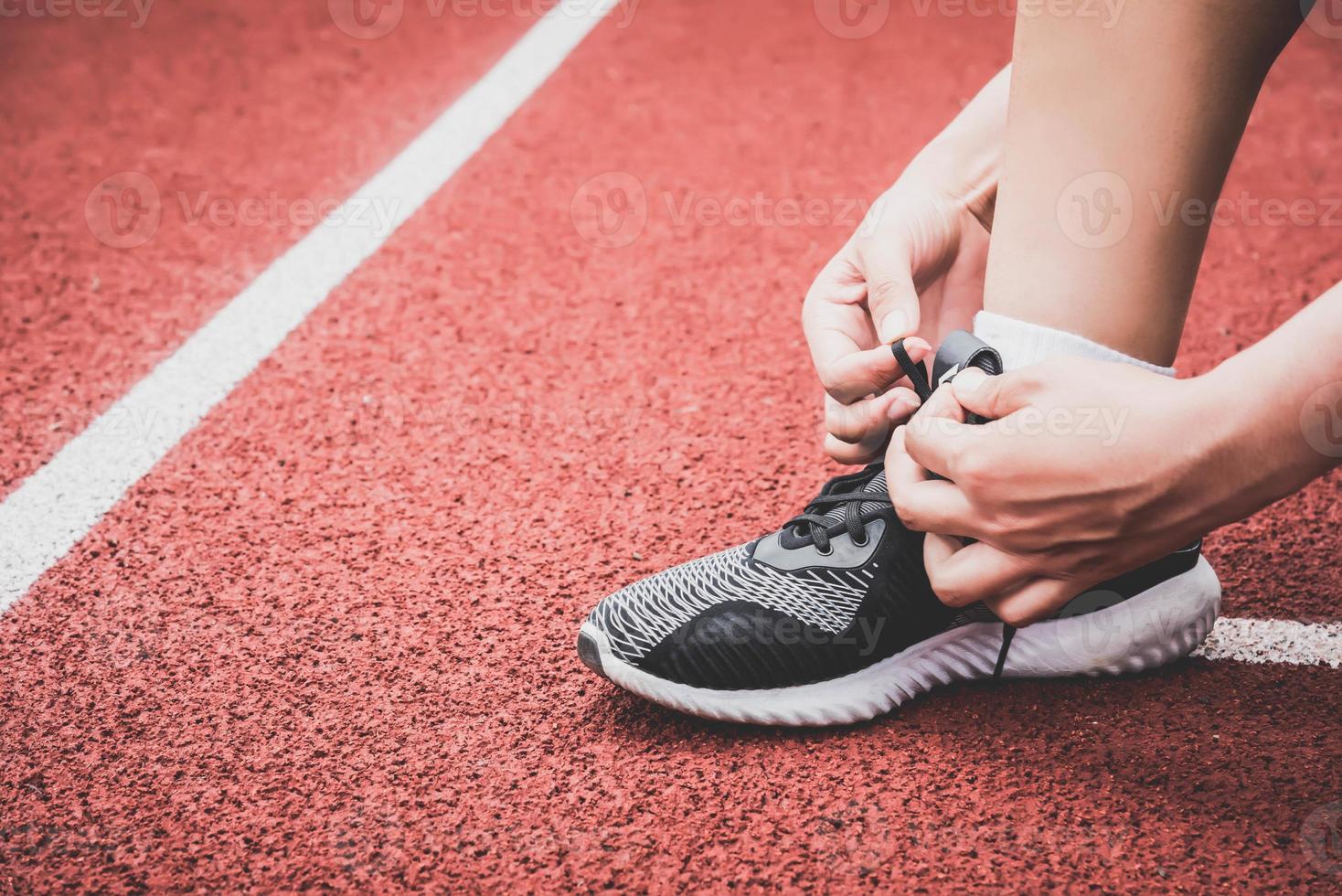 close-up van sportvrouw die sneakers schoenveter touw koppelt foto