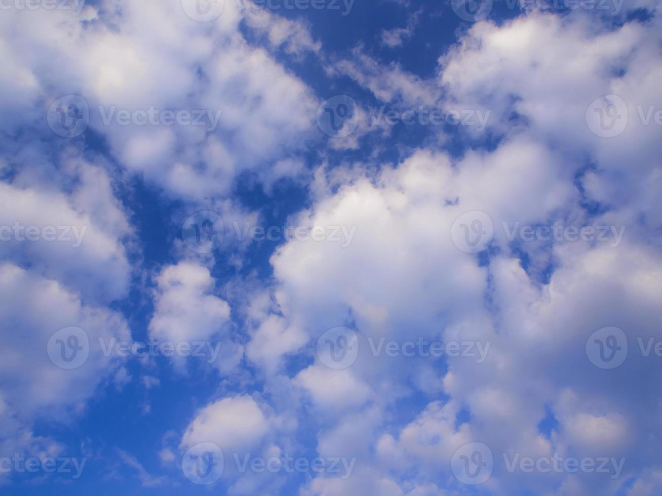 witte pluizige wolken in de blauwe lucht met ochtendlicht foto