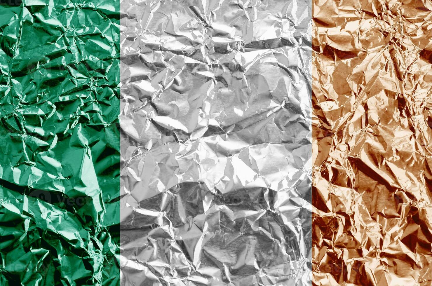 Ierland vlag afgebeeld in verf kleuren Aan glimmend verfrommeld aluminium folie detailopname. getextureerde banier Aan ruw achtergrond foto