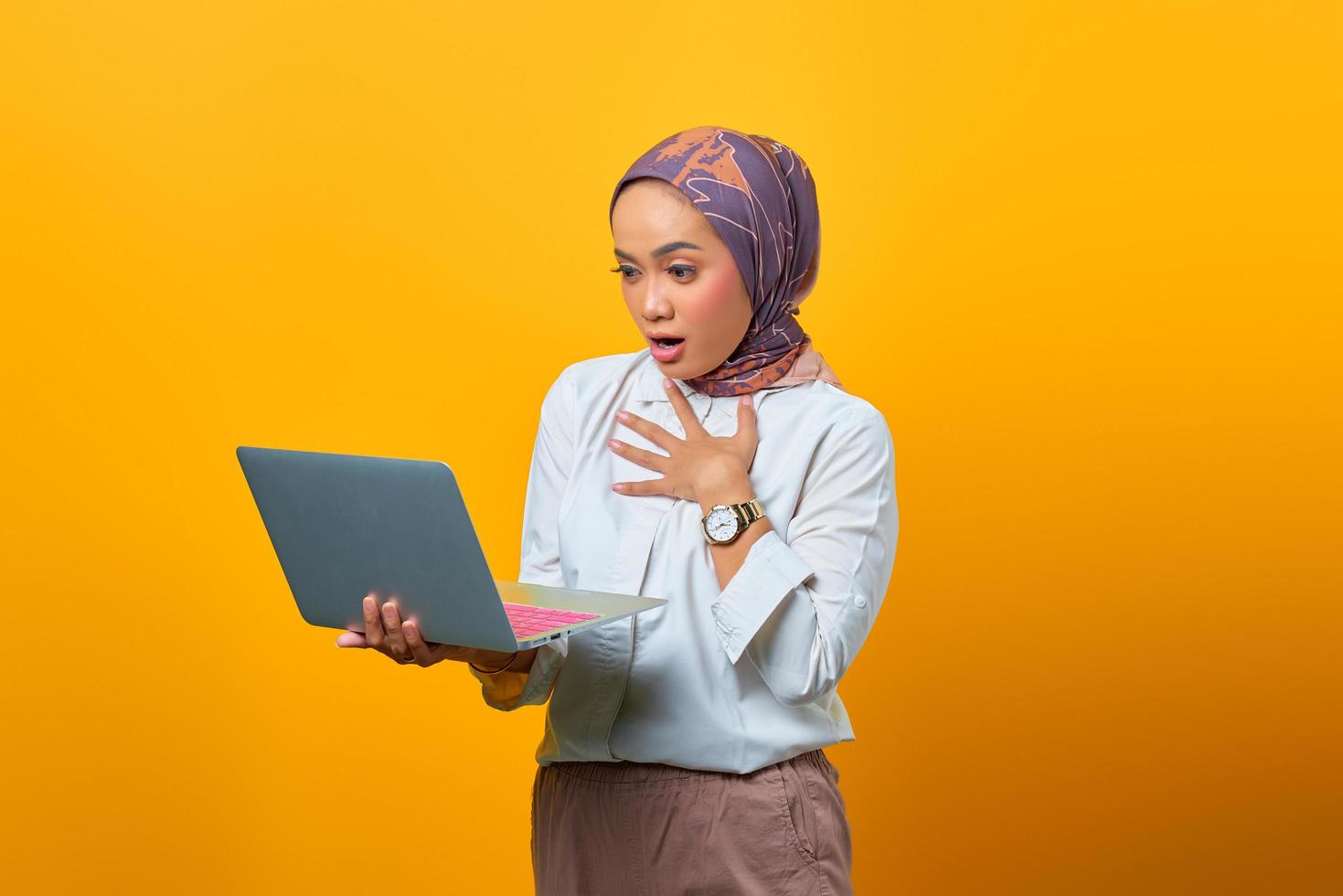 mooie aziatische vrouw met laptop met verbaasde uitdrukking foto