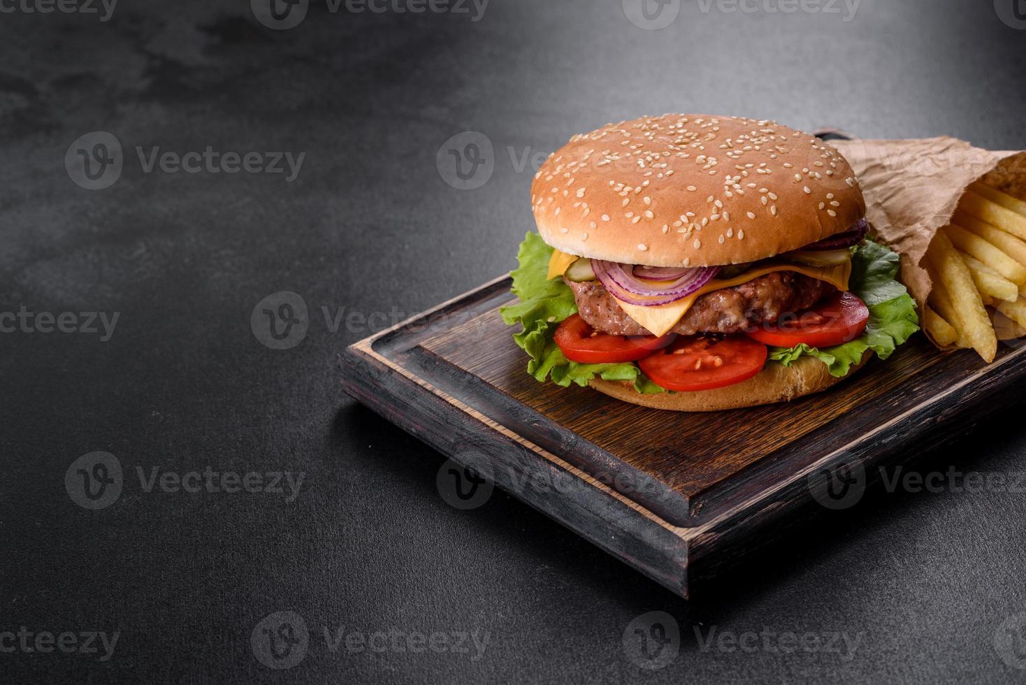 ambachtelijke rundvleesburger en frietjes op een zwarte achtergrond foto