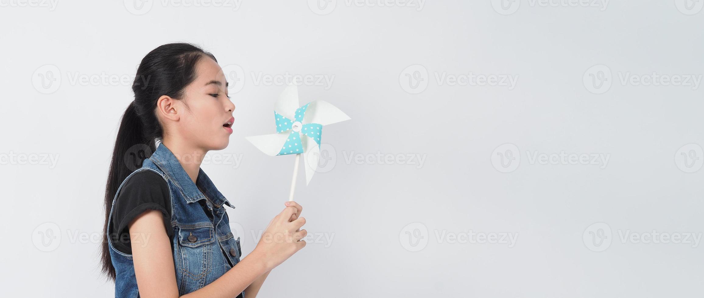 tiener vrouw en papier windmolen speelgoed. tiener met windwielstok foto