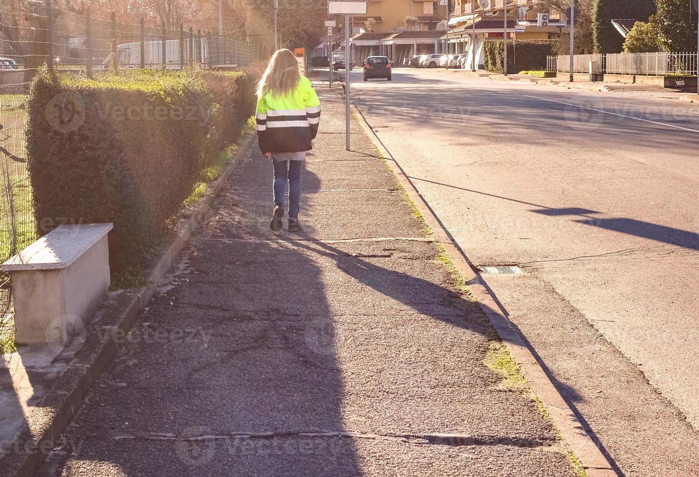 onherkenbare vrouw die bij zonsondergang loopt foto