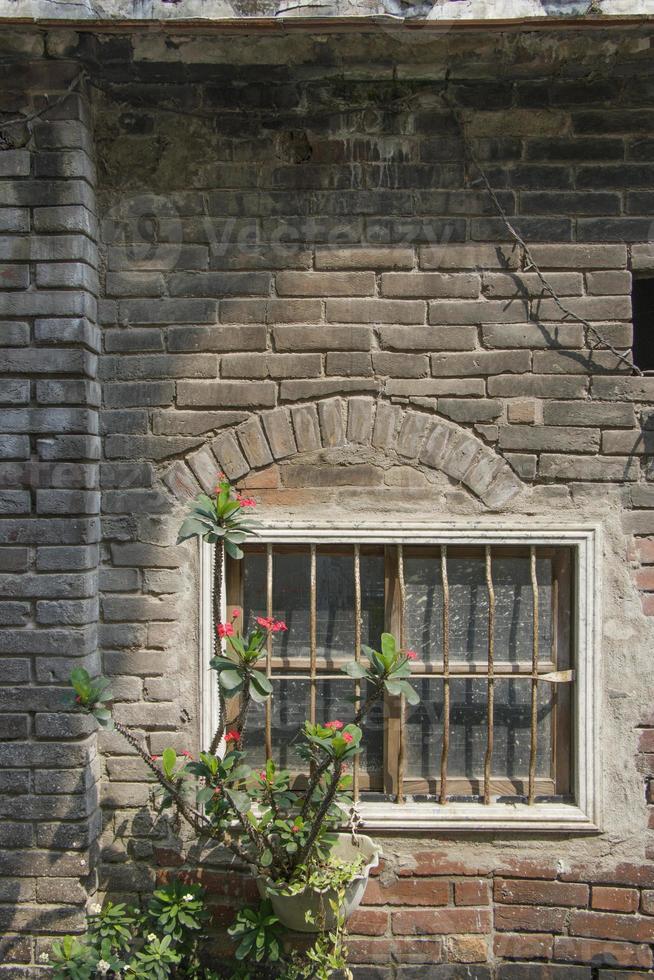 oude ruïne bakstenen gips muur en rustiek raam natuur plantenpot foto