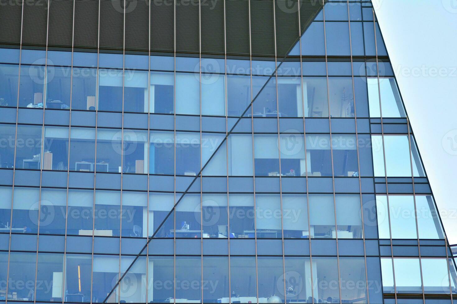 glas gebouw met transparant facade van de gebouw en blauw lucht. structureel glas muur reflecterend blauw lucht. abstract modern architectuur fragment. hedendaags bouwkundig achtergrond. foto