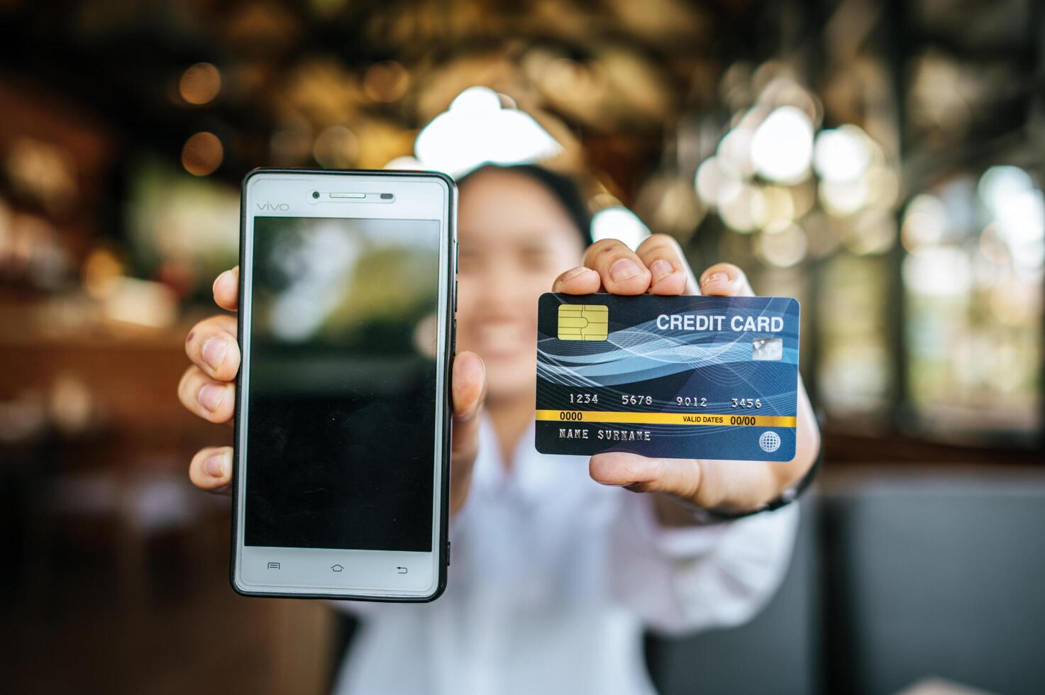 smartphone en creditcard met vrouw bij de hand foto