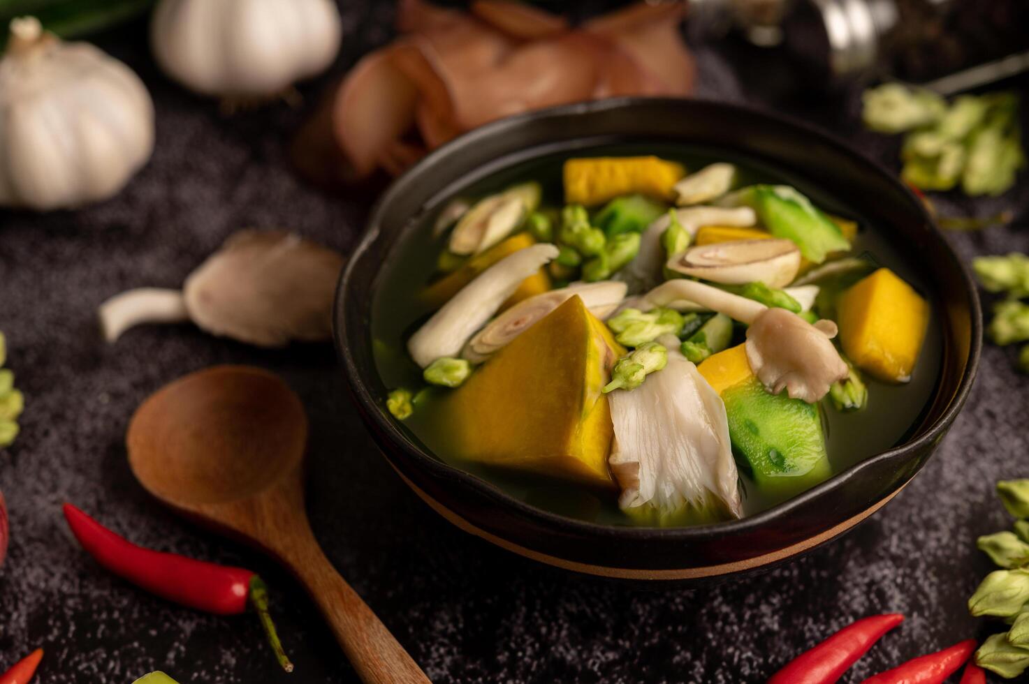 kaeng liang in een kom met kruiden op een zwarte cementvloer. foto