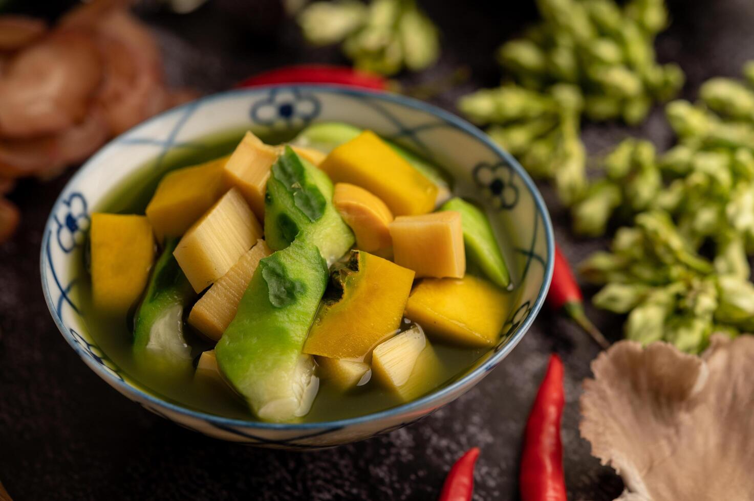 kaeng liang in een kom met kruiden op een zwarte cementvloer. foto