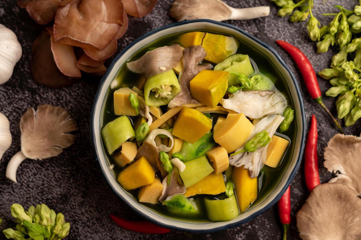 kaeng liang in een kom met kruiden op een zwarte cementvloer. foto