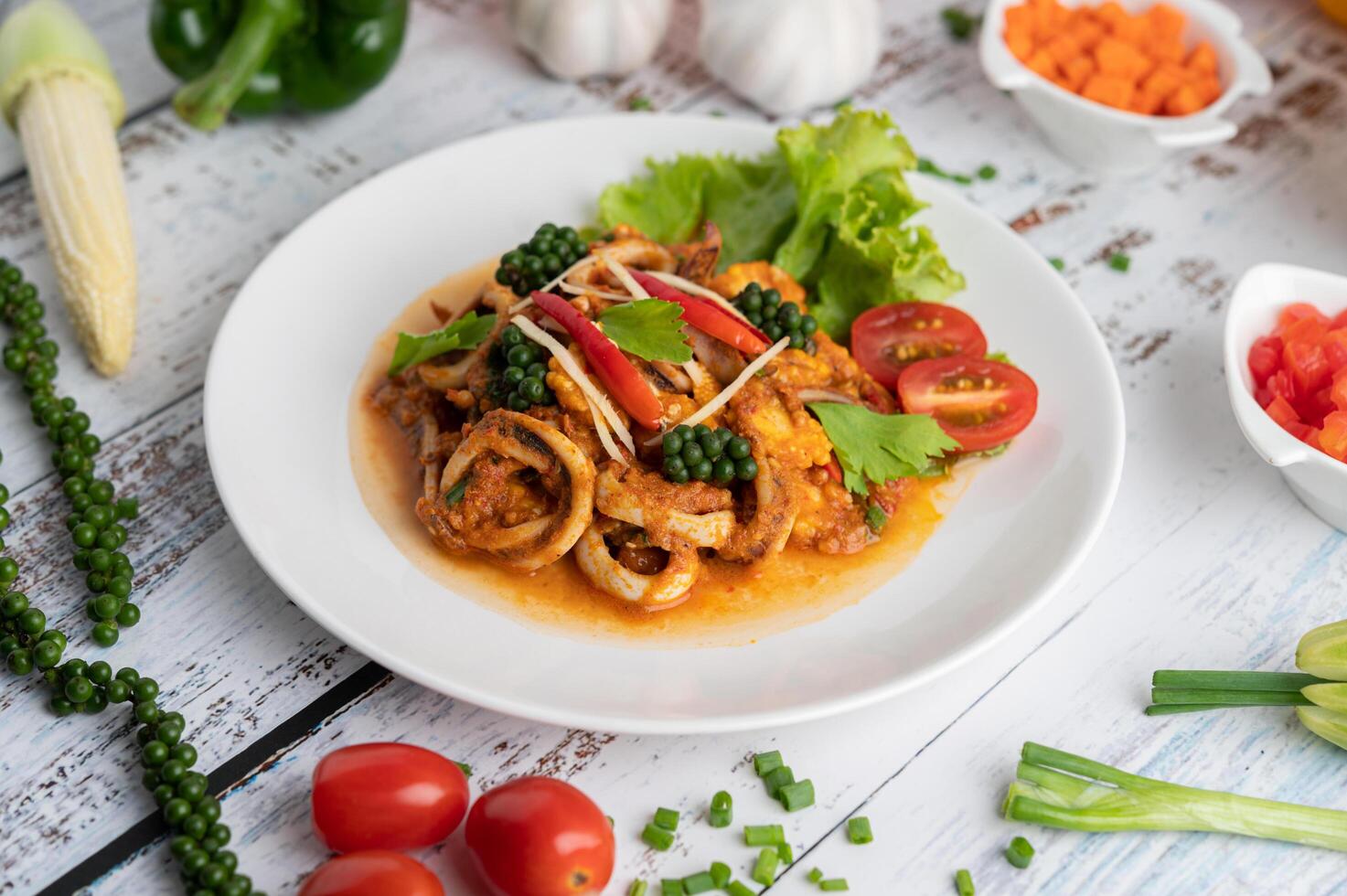 Roergebakken inktvis met currypasta in witte plaat. foto