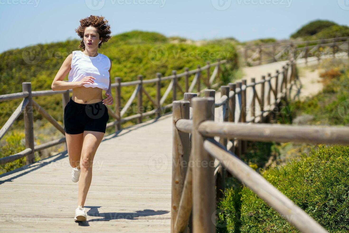 sportief vrouw rennen langs loopbrug in platteland foto