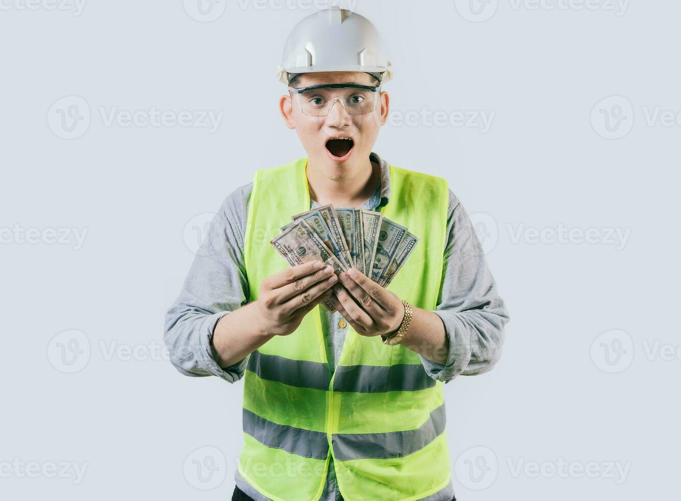 verrast ingenieur in helm Holding geld geïsoleerd. versteld staan mannetje ingenieur Holding bankbiljetten Aan geïsoleerd achtergrond foto