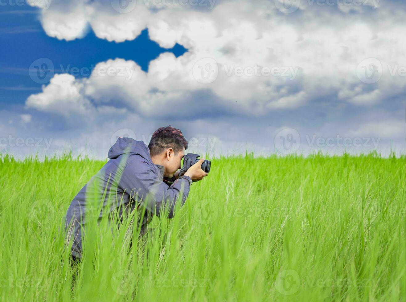Mens nemen afbeelding met camera in de veld, fotograaf in de veld- nemen een afbeelding, latino Mens in een groen veld- nemen een afbeelding foto
