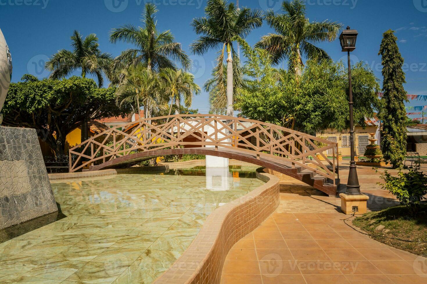 kant visie van een klein houten brug over- een water fontein in een kalmte park. nagarote centraal park. visie van een mooi hoor en ontspannen park met een water fontein. traditioneel park van nagarote, Nicaragua foto