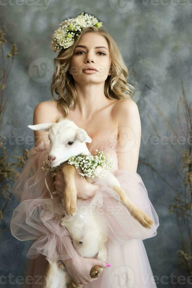 een jong blond vrouw in een luchtig roze jurk met een wit kind. voorjaar portret van een vrouw. foto