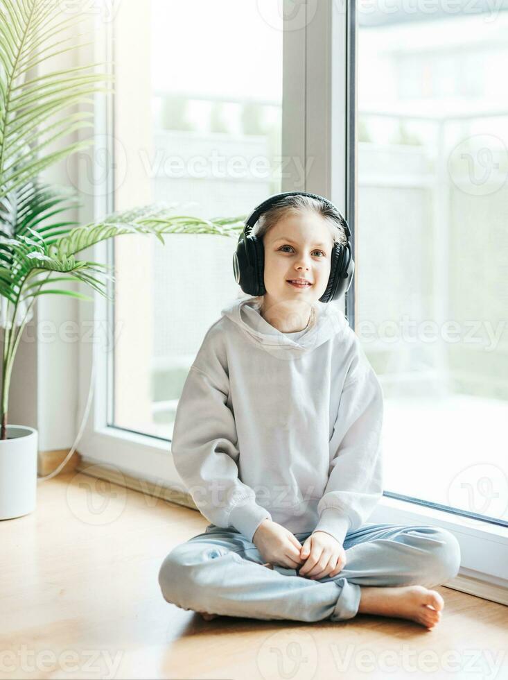 schattig weinig meisje luisteren naar muziek- in hoofdtelefoons foto