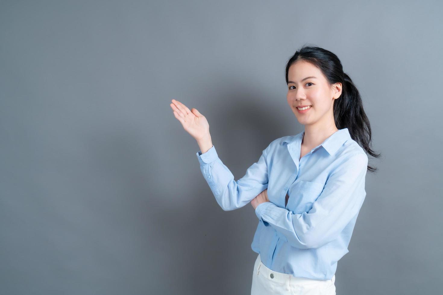 aziatische vrouw met hand die aan kant presenteert foto