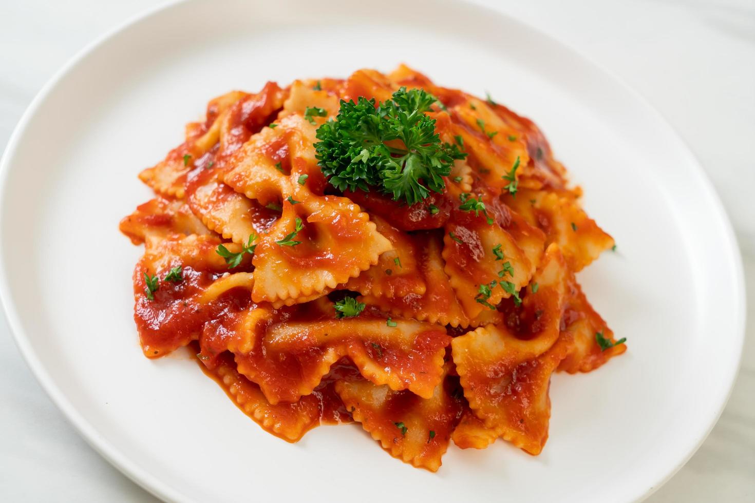 farfalledeegwaren in tomatensaus met peterselie foto