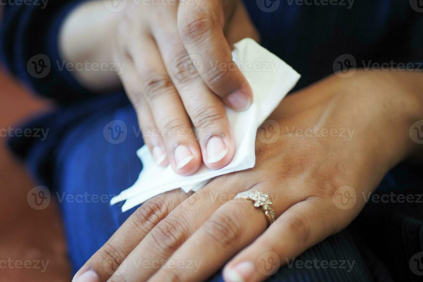 Dames desinfecteren zijn handen met een nat veeg. foto