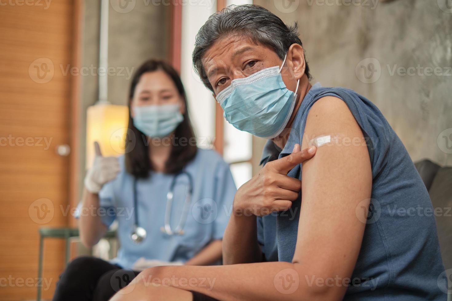 oudere patiënt wijst vinger naar arm na vaccinatie. foto