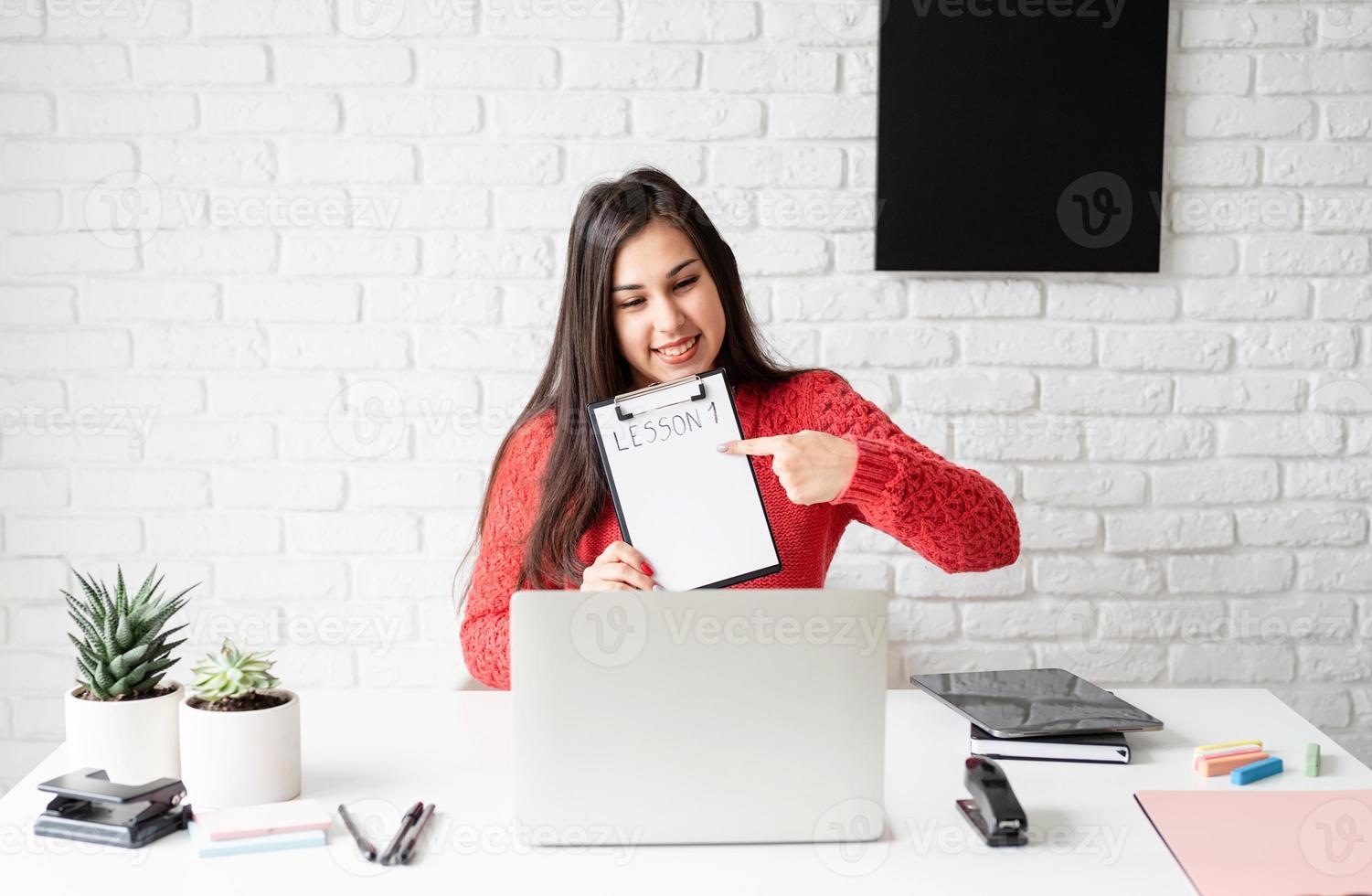 jonge latijnse vrouw in rode trui die online engels leert foto