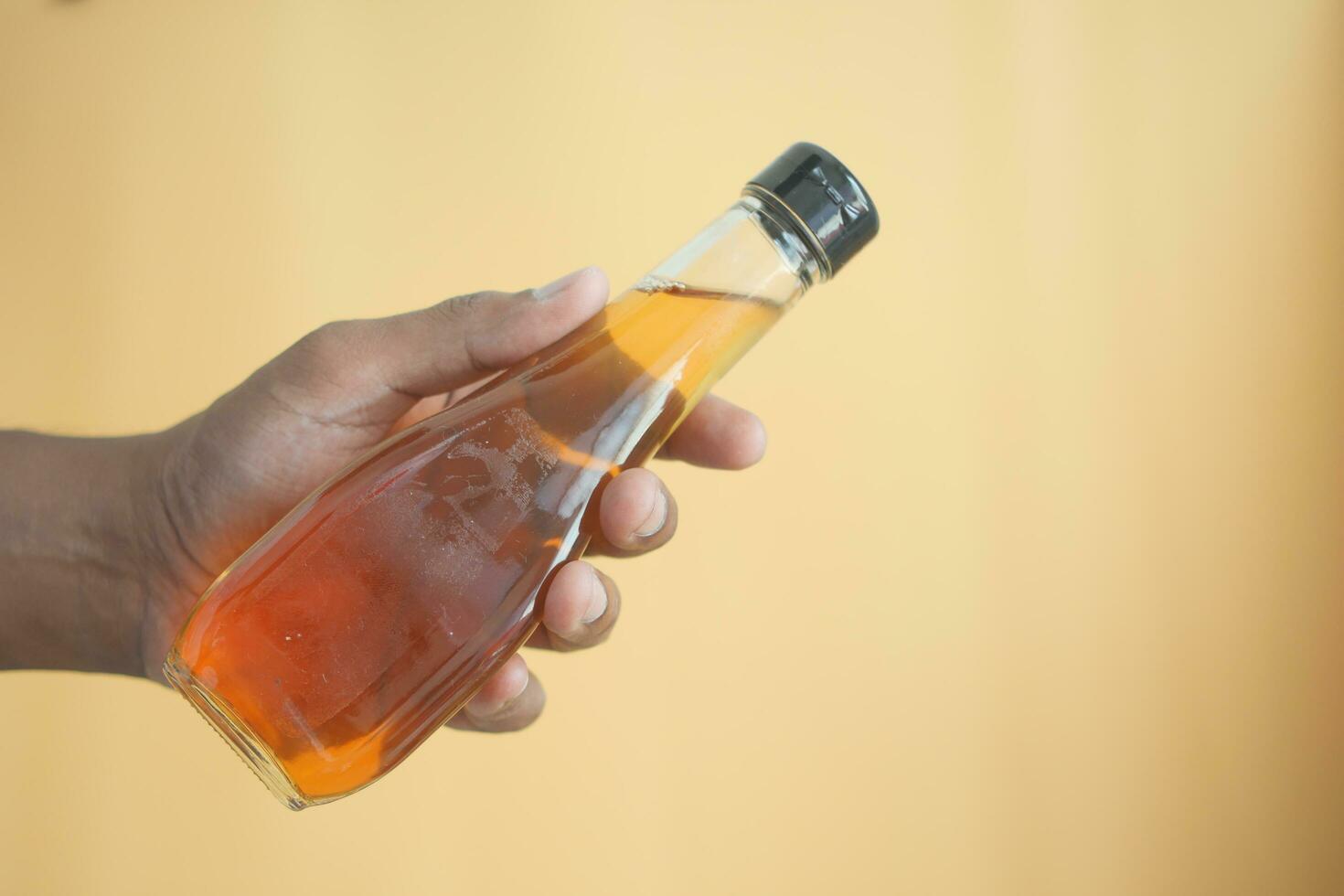 hand- houden een fles van appel azijn foto