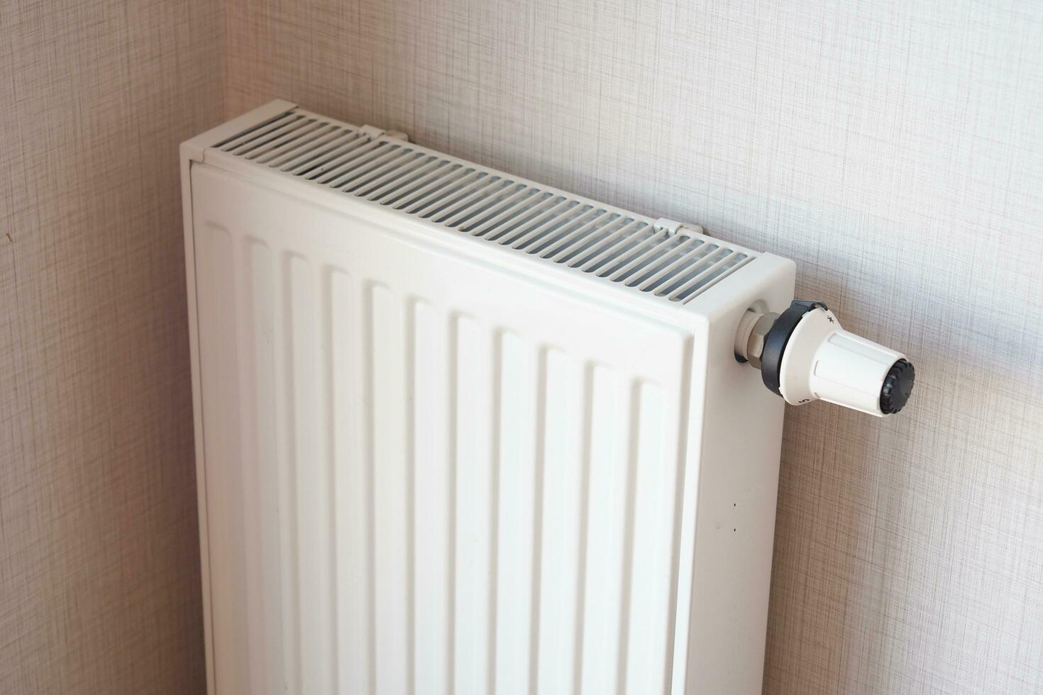 wit radiator Aan grijs wit muur. appartement verwarming installatie systeem, foto