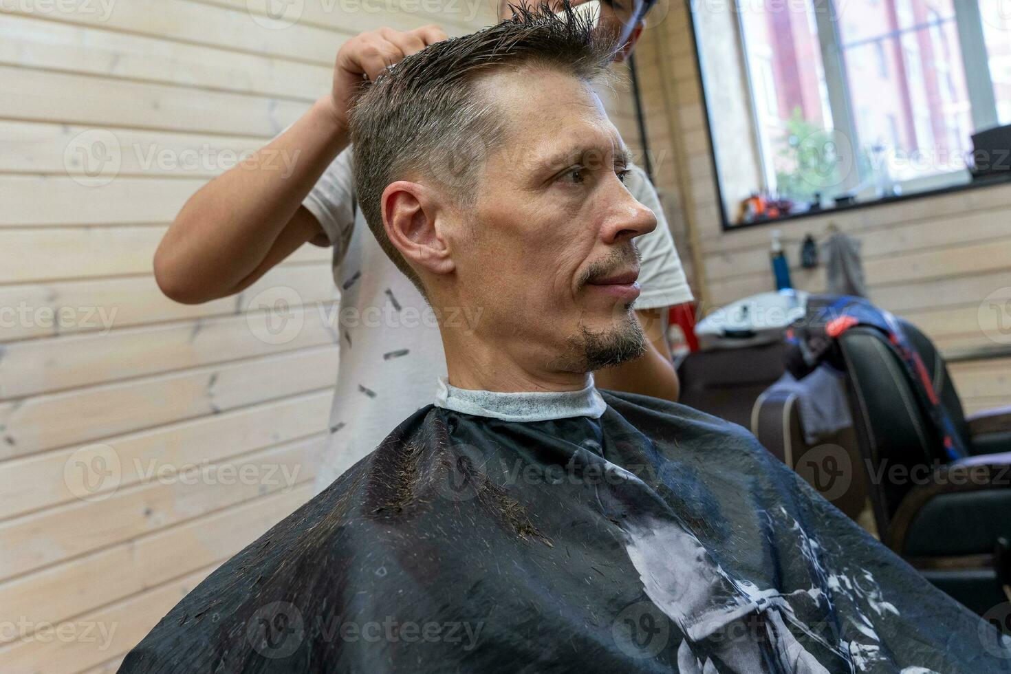 professioneel kapper bezuinigingen een man's haar. bezoek naar de kapper winkel foto