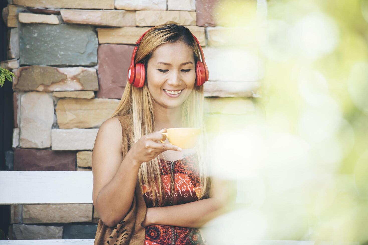 gelukkige jonge vrouw ontspan met luister naar favoriete muziek in café foto