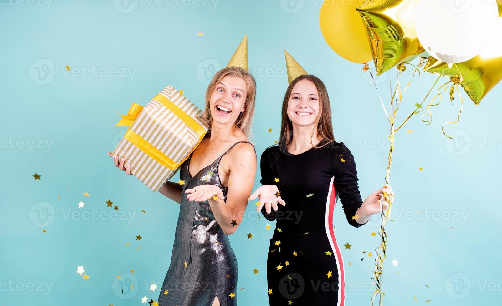 vrouwen met ballonnen die verjaardag vieren op blauwe achtergrond foto