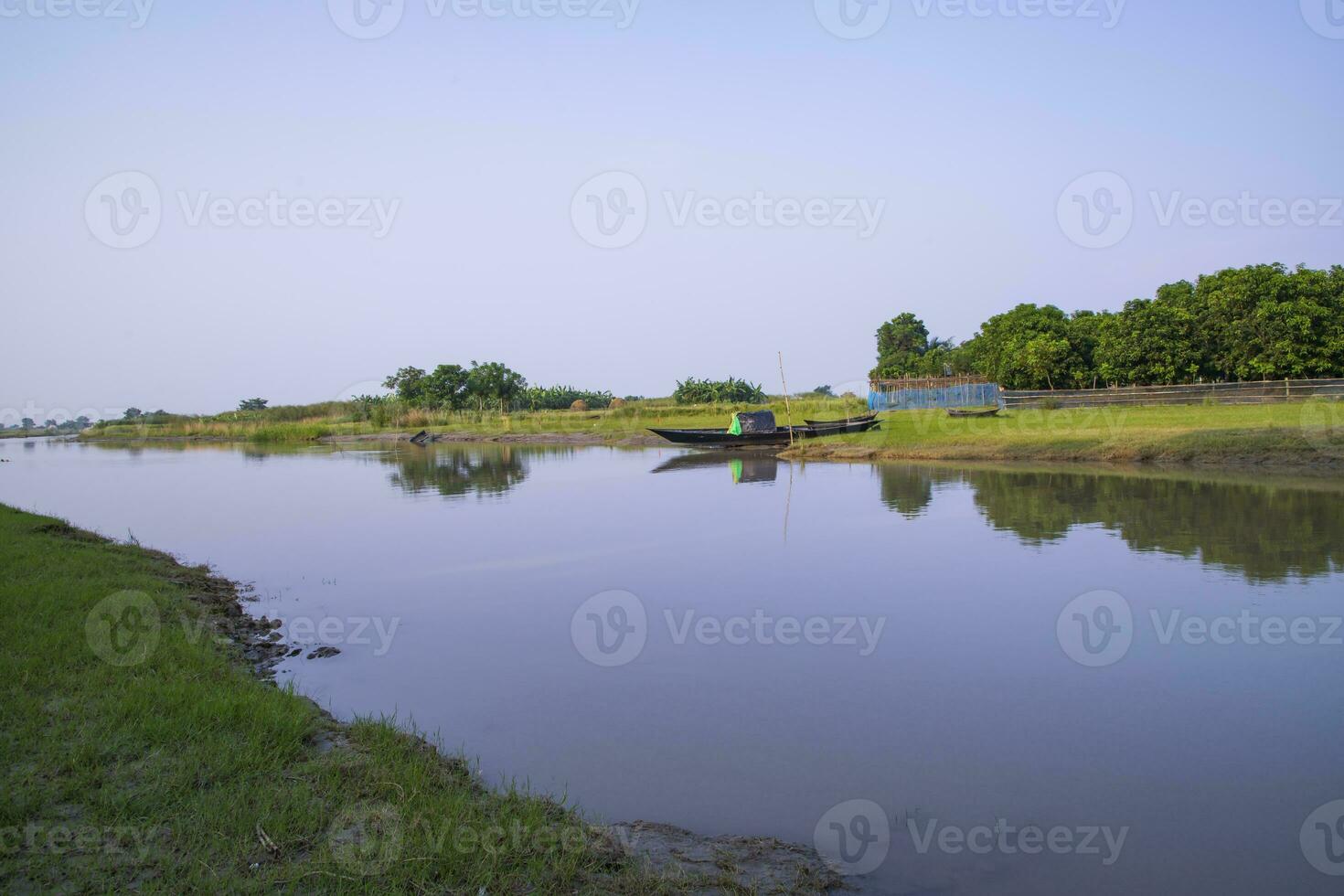 kanaal met groen gras en vegetatie weerspiegeld in de water in de buurt padma rivier- in Bangladesh foto