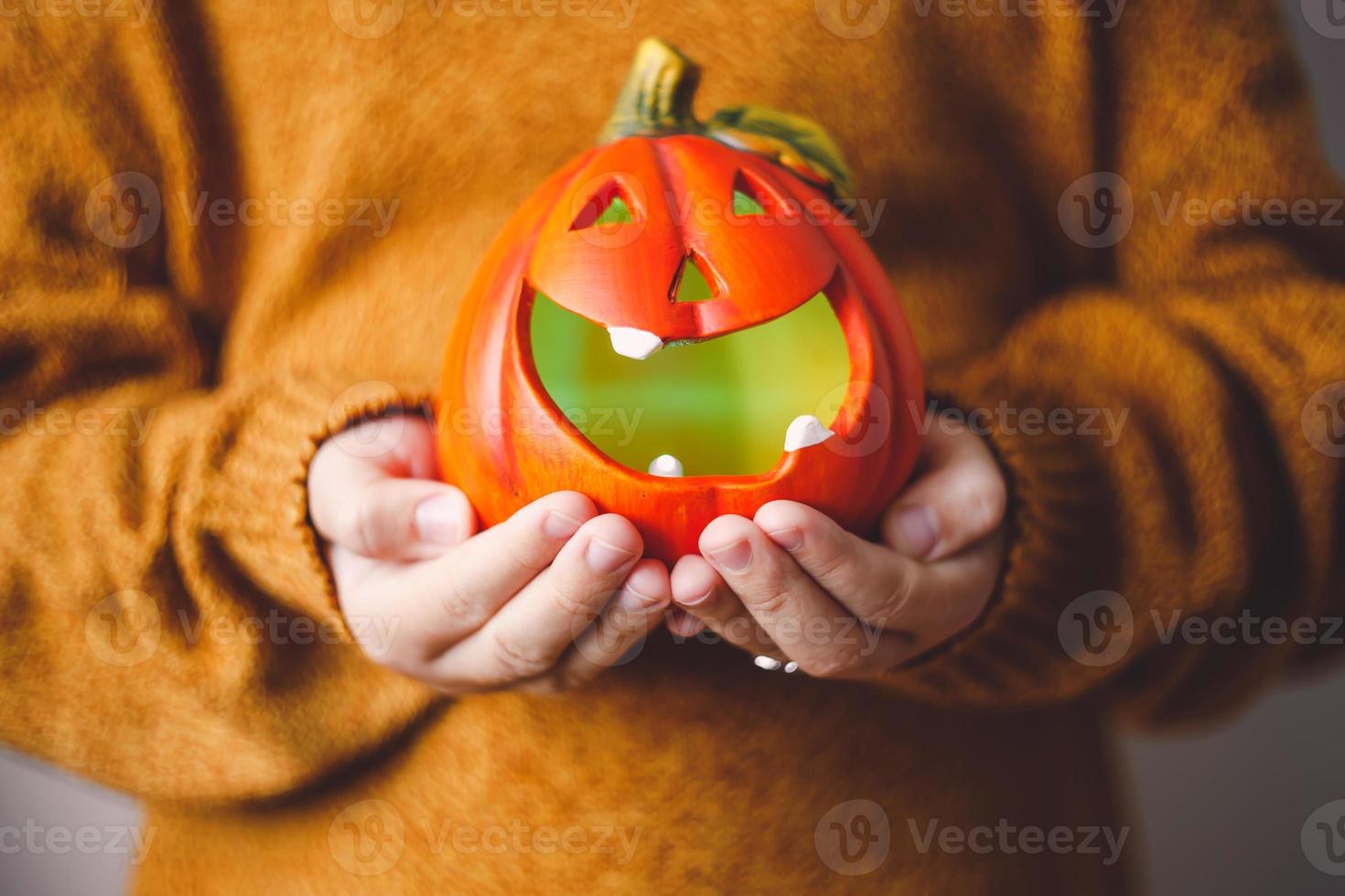 Halloween-pompoenlamp in de handen van kinderen. foto