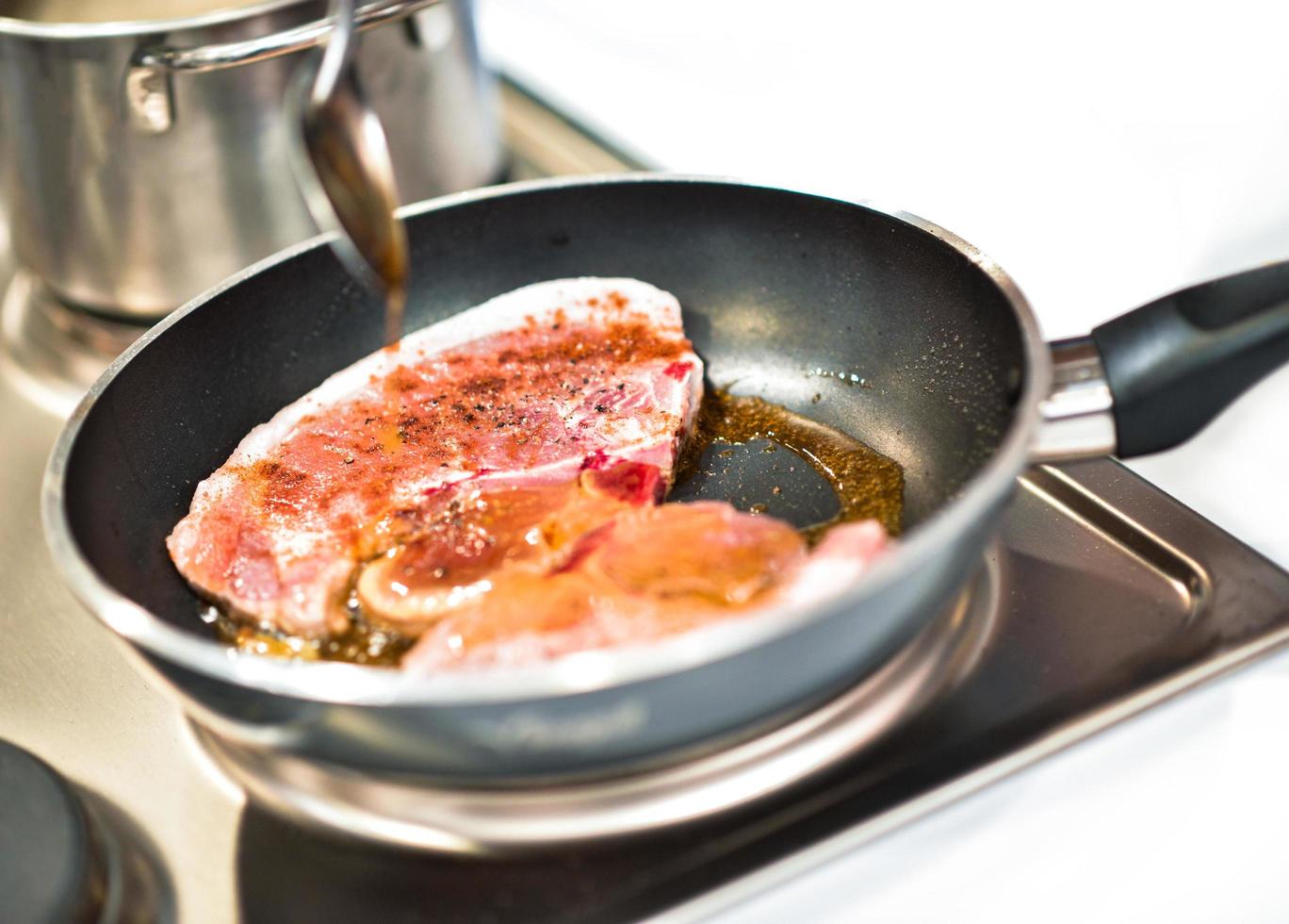 chef-kok koken, vlees steaks koken in pan op keuken foto