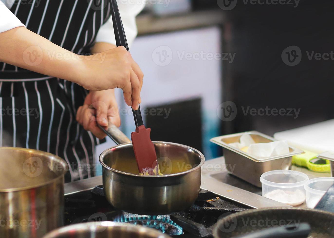 chef-kok koken, chef-kok die voedsel bereidt, chef-kok die schotel in de keuken decoreert foto