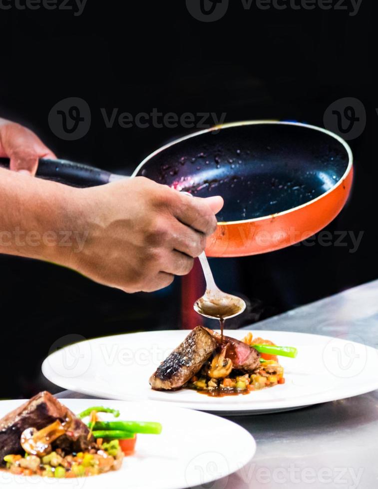 chef-kok die voedsel in de keuken bereidt, chef-kok kookt, chef-kok decoreert schotel foto