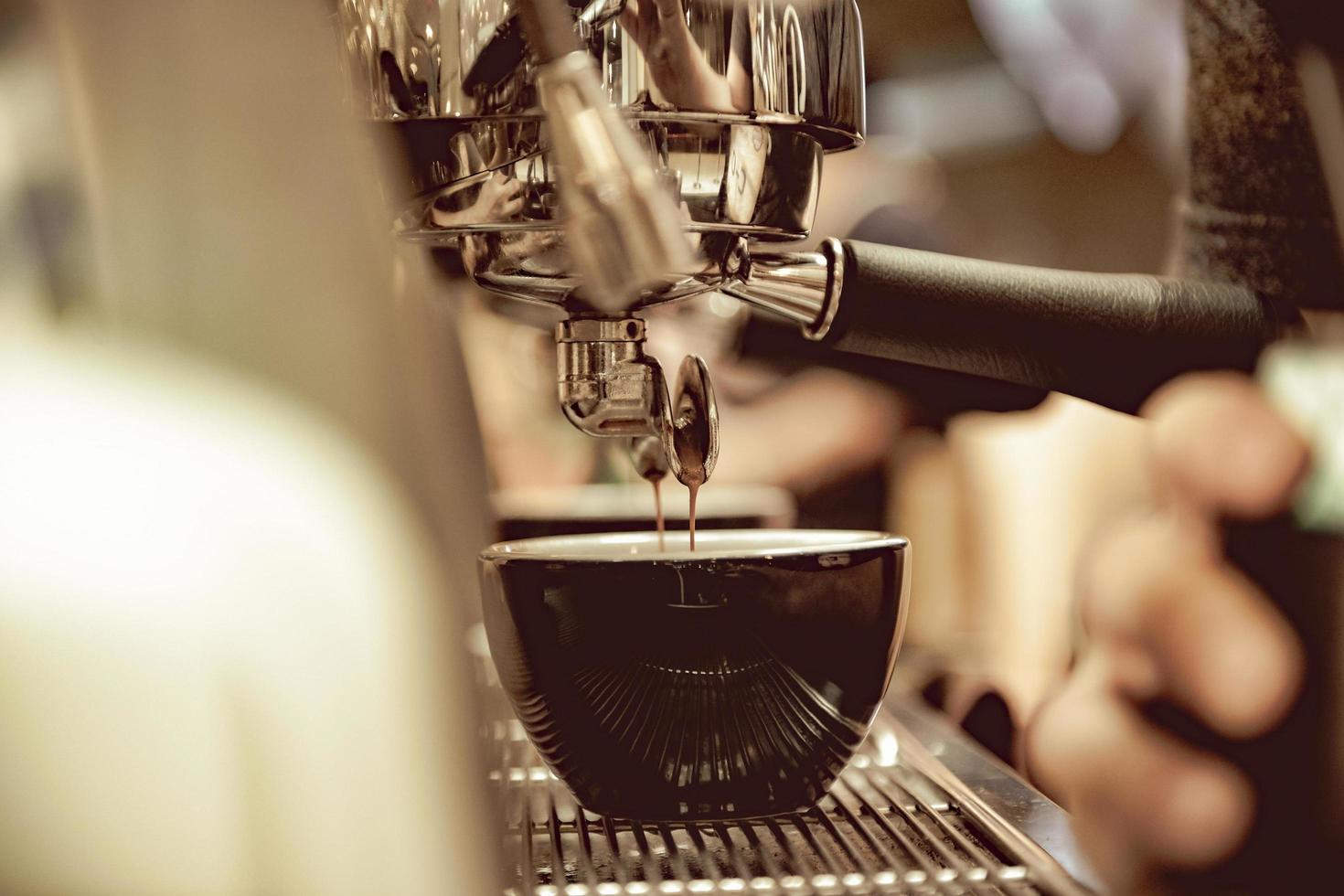 espresso shot uit koffiezetapparaat in coffeeshop foto