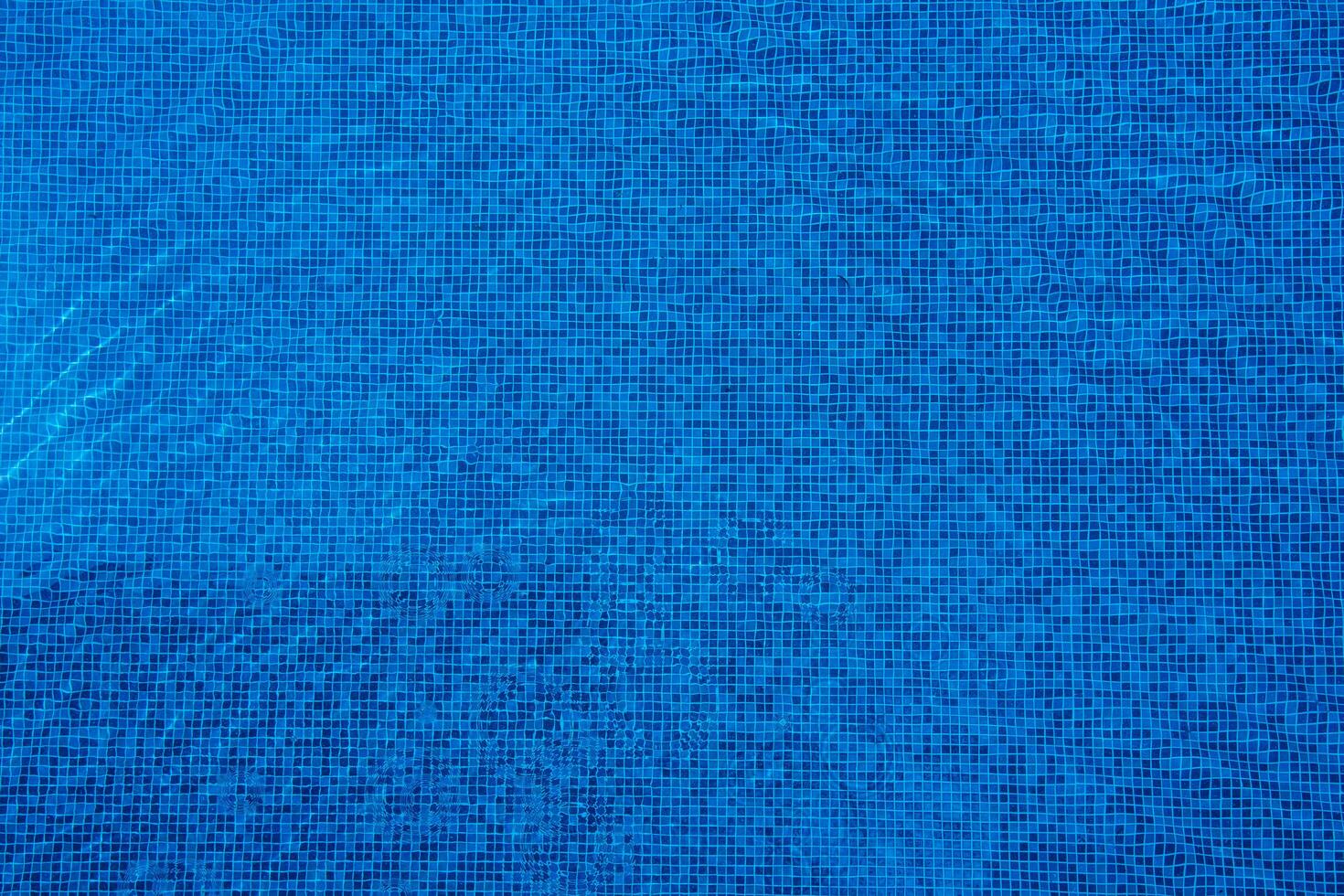 licht weerspiegelt uit de oppervlakte van de blauw zwemmen zwembad. foto
