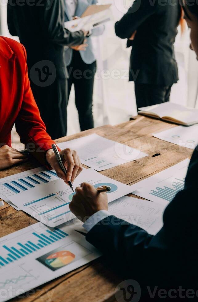 financiële analisten analyseren zakelijke financiële rapporten over een investeringsproject voor digitale tabletplanning tijdens een discussie op een bijeenkomst van bedrijven die de resultaten van hun succesvolle teamwerk laten zien. foto