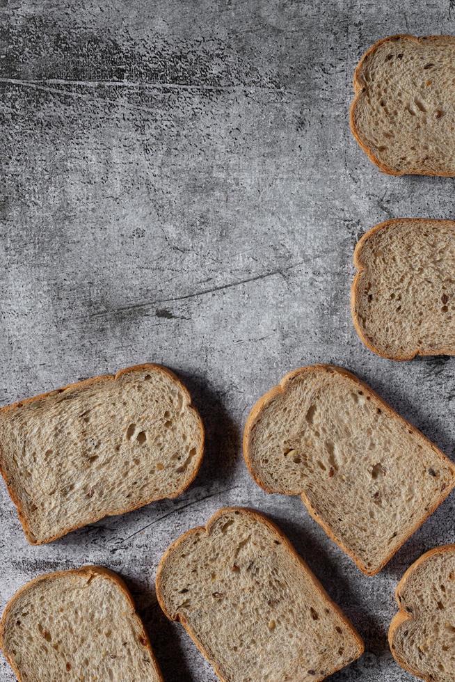 gesneden graan volkoren brood op donkere rustieke houten achtergrond foto