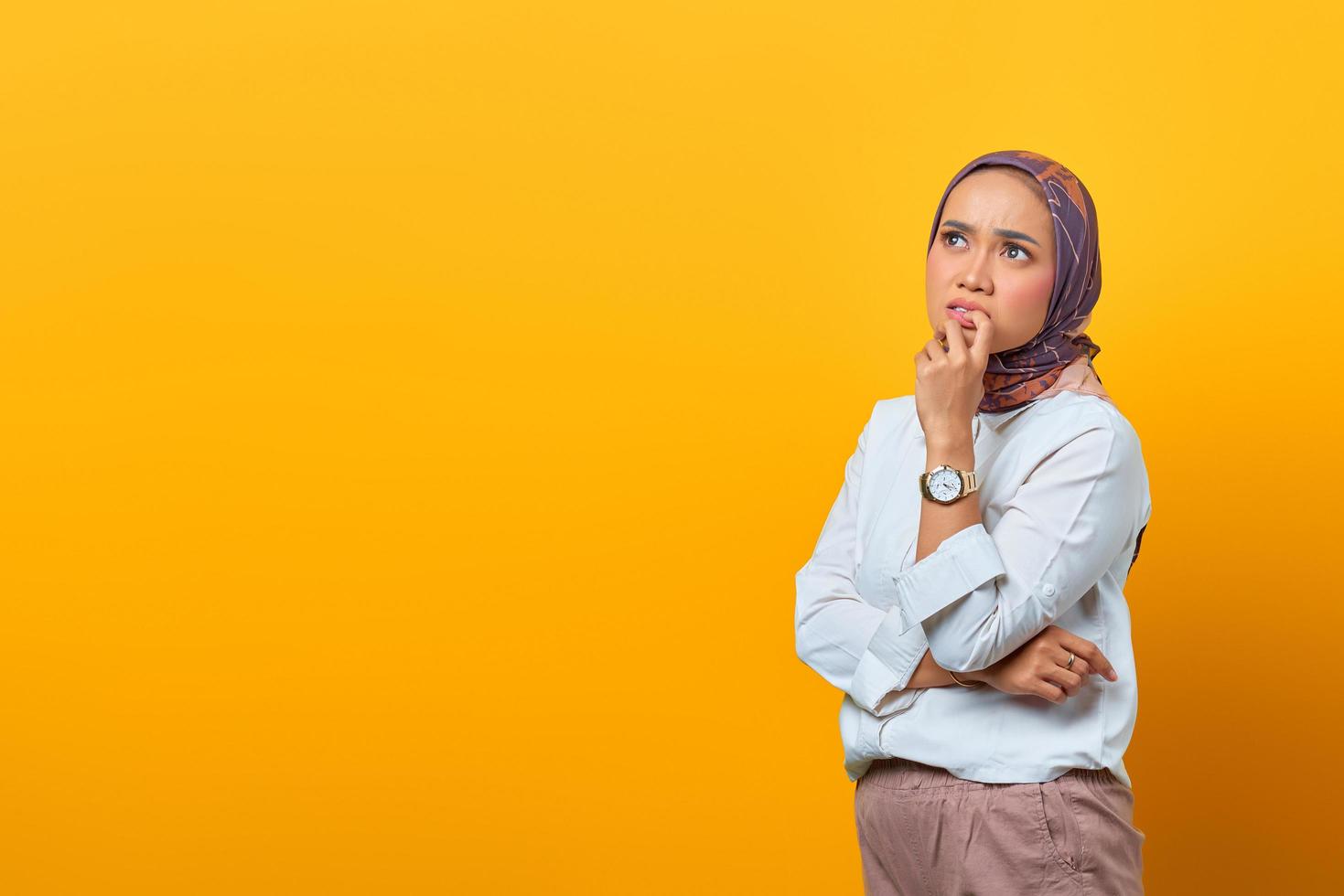 denkende aziatische vrouw die lippen aanraakt en naar lege ruimte kijkt foto