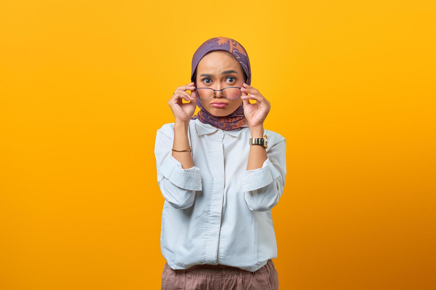 aantrekkelijke aziatische vrouw die een bril met beide handen vasthoudt foto