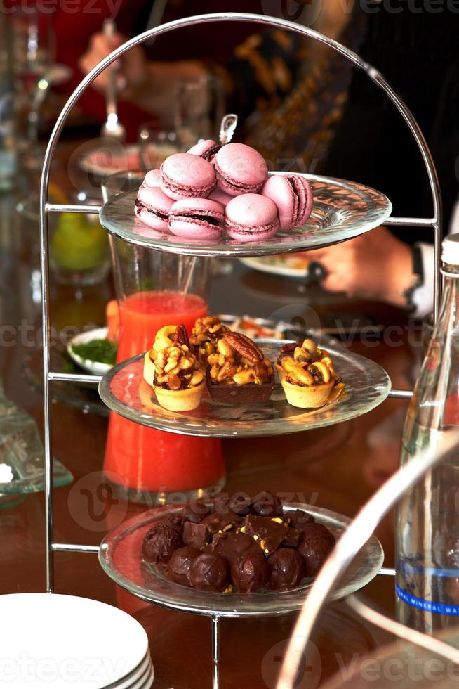 macaron, mandcakes en chocolaatjes liggend op een speciale standaard foto